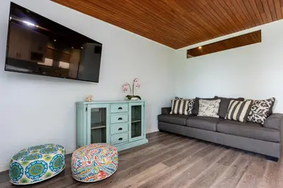 a living room with a couch and a tv at Flamingo Marina Cove 404- Oceanfront Condo in Playa Flamingo