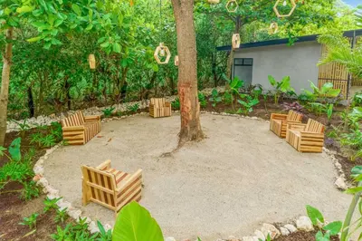 a group of chairs sitting around a tree at Pipa's Surf House Marbella Guanacaste in Cuajiniquil