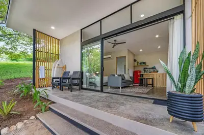a house with large glass doors and a potted plant at Pipa's Surf House Marbella Guanacaste in Cuajiniquil
