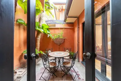 a patio with a table and chairs and a plant at Villa Cerca Del Mar #6- 3Br House With Pool in Tamarindo