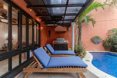 a patio with blue chairs and a swimming pool at Villa Cerca Del Mar #6- 3Br House With Pool in Tamarindo