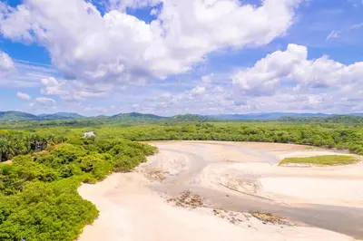an aerial view of a river with trees and clouds at Villa Cerca Del Mar #6- 3Br House With Pool in Tamarindo