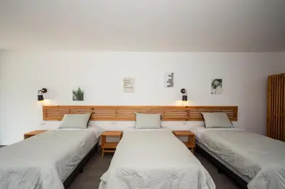 a row of three beds in a room at Yuli Hotel in Uvita