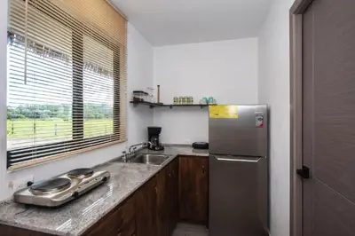 a kitchen with a stainless steel refrigerator and a sink at Yuli Hotel in Uvita