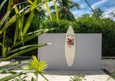a surfboard is leaning against a white wall at Yuli Hotel in Uvita