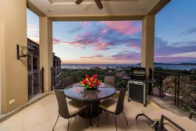 a patio with a table and chairs on a balcony at Matapalo 605- 2 Bedroom Ocean View Condo At Tamarindo in Tamarindo