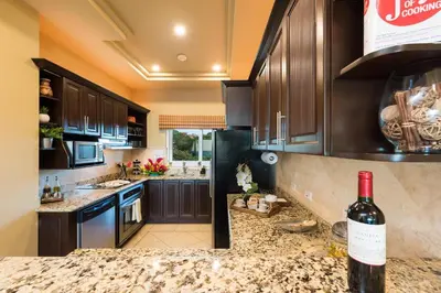 a kitchen with a bottle of wine on the counter at Matapalo 605- 2 Bedroom Ocean View Condo At Tamarindo in Tamarindo