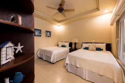 a bedroom with two beds and a ceiling fan at Matapalo 605- 2 Bedroom Ocean View Condo At Tamarindo in Tamarindo