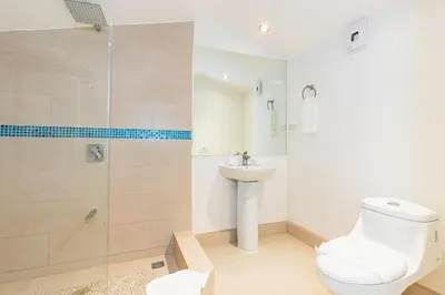 a bathroom with a toilet and a sink and a shower at El Diria 301- Ocean View 3 Bedroom Condo in Tamarindo