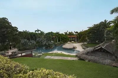 a swimming pool in a resort with trees and grass at El Diria 301- Ocean View 3 Bedroom Condo in Tamarindo