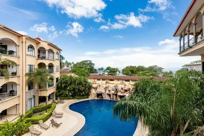 an image of a swimming pool between two buildings at Sunrise 33- 3 Bedroom Poolside Condo in Tamarindo
