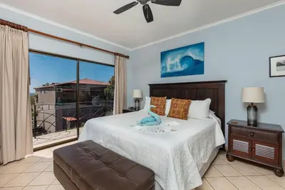 a bedroom with a bed and a large window at Sunrise 43 - 2 Bedroom Ocean View Condo in Tamarindo