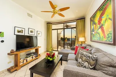 a living room with a couch and a tv at Sunrise 43 - 2 Bedroom Ocean View Condo in Tamarindo