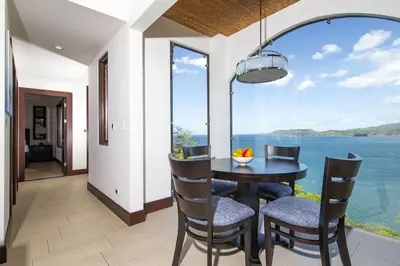 a dining room with a table and chairs and a large window at 360 Splendor 101A Ocean View Breakfast in Playa Flamingo