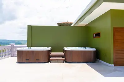 two jacuzzi tubs sitting on a green wall at 360 Splendor 101A Ocean View Breakfast in Playa Flamingo
