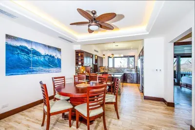a dining room with a ceiling fan and a table and chairs at 360 Splendor 207A-Ocean View 2 Br Condo-Breakfast Included! in Playa Flamingo
