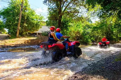 a group of people riding on atvs through a river at 360 Splendor 207A-Ocean View 2 Br Condo-Breakfast Included! in Playa Flamingo