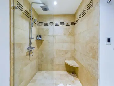 a bathroom with a shower with a bench in it at 360 Splendor 301-Ocean View Condo-Breakfast Included! in Playa Flamingo
