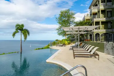 a house with a swimming pool next to the ocean at 360 Splendor 301-Ocean View Condo-Breakfast Included! in Playa Flamingo