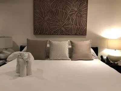 a bedroom with a large white bed with two lamps at 360 Splendor 101F Ocean View 2Br Breakfast in Playa Flamingo