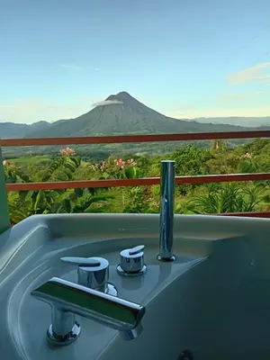 a bath tub with a view of a mountain at Encanto Arenal lodge in Fortuna