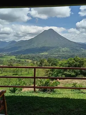 a view of a mountain from a fence at Encanto Arenal lodge in Fortuna