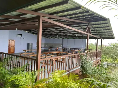 a pavilion with tables and chairs on a deck at Encanto Arenal lodge in Fortuna
