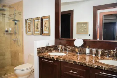 a bathroom with two sinks and a shower and a toilet at 360 Splendor 308A-Ocean View 2 Br -Breakfast Included! in Playa Flamingo