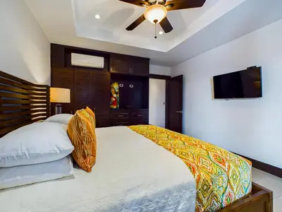 a bedroom with a bed with a ceiling fan at 360 Splendor 405 Ocean View Condo- With Breakfast in Playa Flamingo