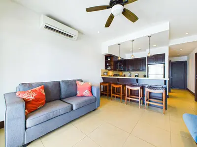 a living room with a couch and a kitchen at 360 Splendor 307B-Ocean View Condo-Breakfast in Playa Flamingo