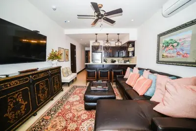 a living room with a couch and a flat screen tv at 360 Splendor 308B Ocean View Condo- With Breakfast in Playa Flamingo
