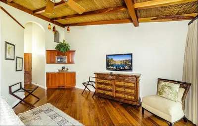 a living room with a tv and a chair at Palms 14 Luxury Beachfront Villa in Playa Flamingo