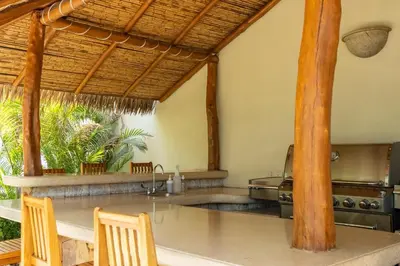 a kitchen with a counter with a sink and a table at Palms 5 Luxury Beachfront Villa in Playa Flamingo