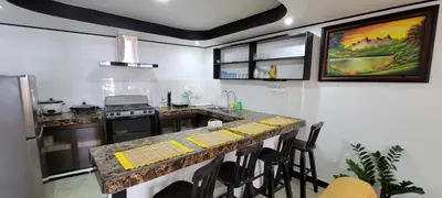 a kitchen with a counter with yellow mats on it at Panda House in Quepos