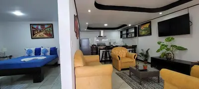 a living room with a bed and a kitchen at Panda House in Quepos