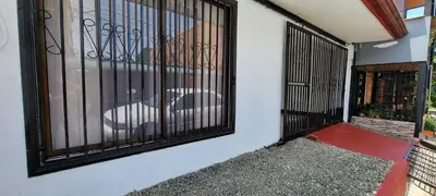 an iron gate on a building with a chair behind it at Panda House in Quepos
