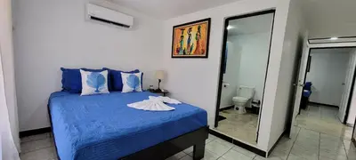 a bedroom with a blue bed and a mirror at Panda House in Quepos