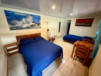 a bedroom with a blue bed and a table and chair at Brisa Del Mar in Playa Hermosa