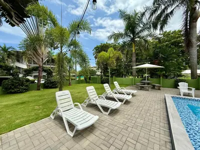 a group of white lounge chairs and a swimming pool at Brisa Del Mar in Playa Hermosa