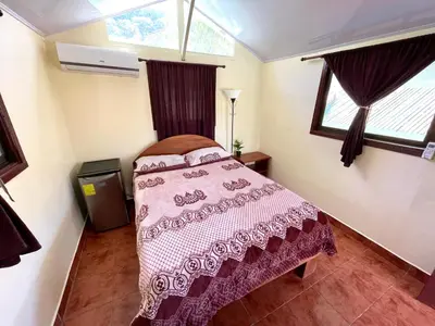a bedroom with a bed in a room with windows at Brisa Del Mar in Playa Hermosa