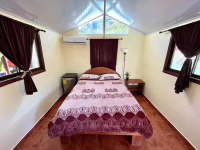 a bedroom with a bed and two windows at Brisa Del Mar in Playa Hermosa