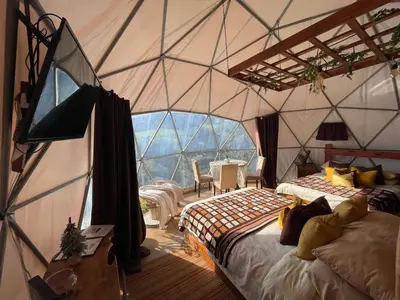 a room with two beds and a large window at Poas Volcano Observatory Lodge & Glamping in Poasito