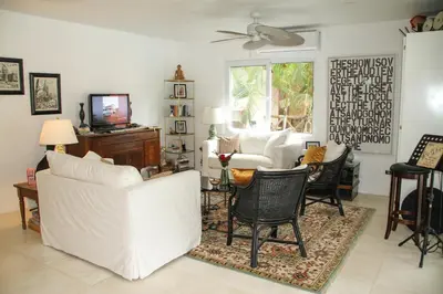 a living room with white furniture and a tv at Casa Vitality Bed and Breakfast - Playa Guiones, Nosara - 4 Minute Walk to the Beach in Nosara