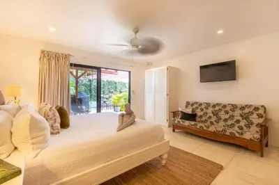 a bedroom with a bed and a couch at Casa Vitality Bed and Breakfast - Playa Guiones, Nosara - 4 Minute Walk to the Beach in Nosara