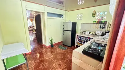 a kitchen with a refrigerator and a stove in it at The Corner House - Hospedaje con Encanto en Tortuguero in Tortuguero