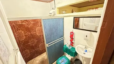 a small bathroom with a toilet and a sink at The Corner House - Hospedaje con Encanto en Tortuguero in Tortuguero