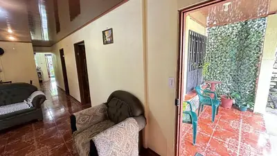 a living room with a couch and a chair at The Corner House - Hospedaje con Encanto en Tortuguero in Tortuguero