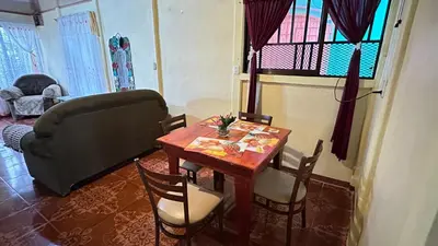 a living room with a table and a couch at The Corner House - Hospedaje con Encanto en Tortuguero in Tortuguero