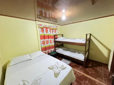 a room with two beds and a bunk bed at The Corner House - Hospedaje con Encanto en Tortuguero in Tortuguero