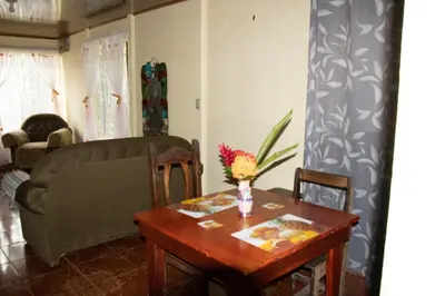 a living room with a table and a couch at The Corner House - Hospedaje con Encanto en Tortuguero in Tortuguero